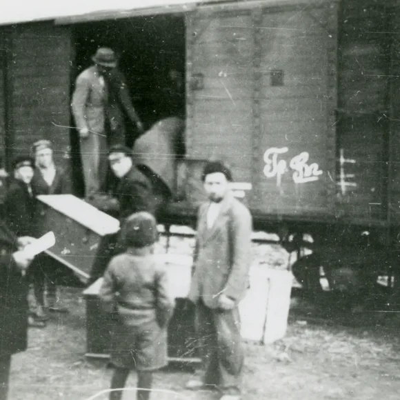Personen laden Gepäck in einen Eisenbahnwagon. Die Szene steht in Zusammenhang mit der Umsiedlung der Dobrudschadeutschen, aufgenommen in Cobadin (1940). Foto aus einem Album im Nachlass Johannes Niermann/Otto Klett.